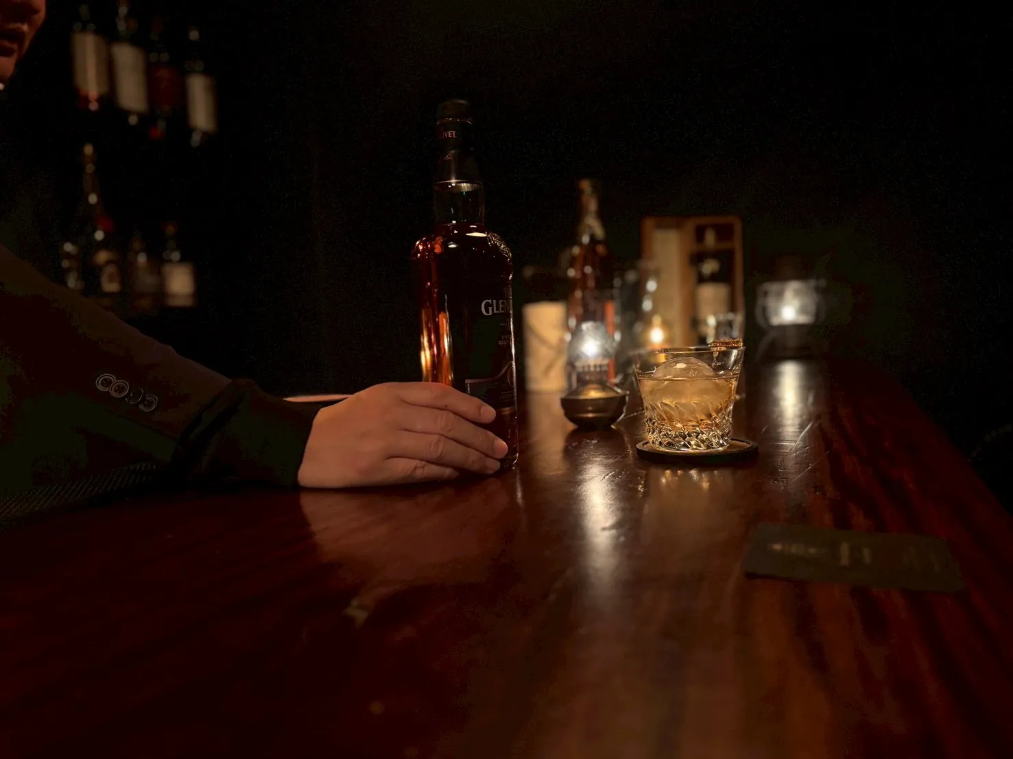 ジャケットを着てBAR JACKETでグラスを傾ける様子